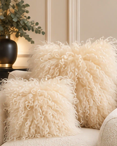 Cream Mongolian fur cushions in 45cm and 60cm on a cream boucle sofa [shade: Cream]