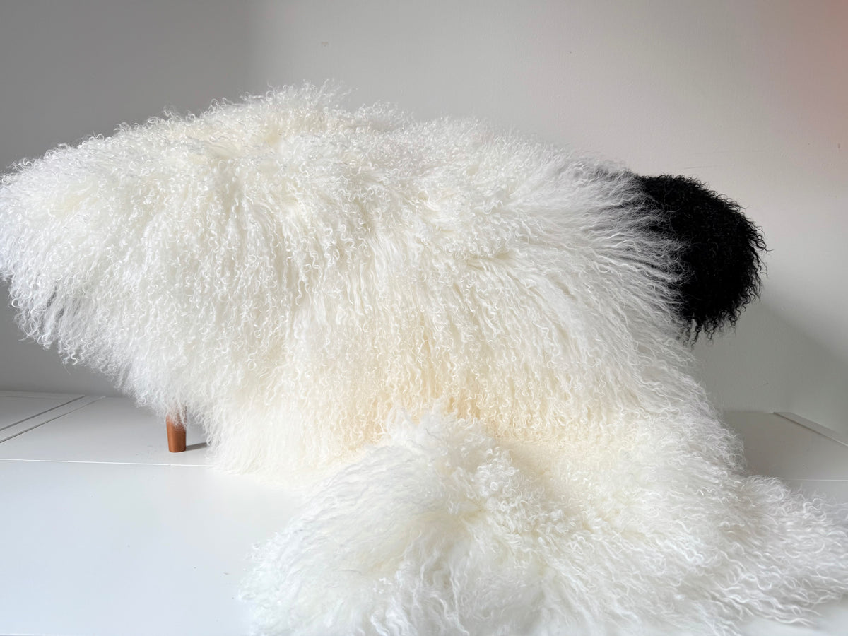 Natural Mongolian fur single throw draped over a bench