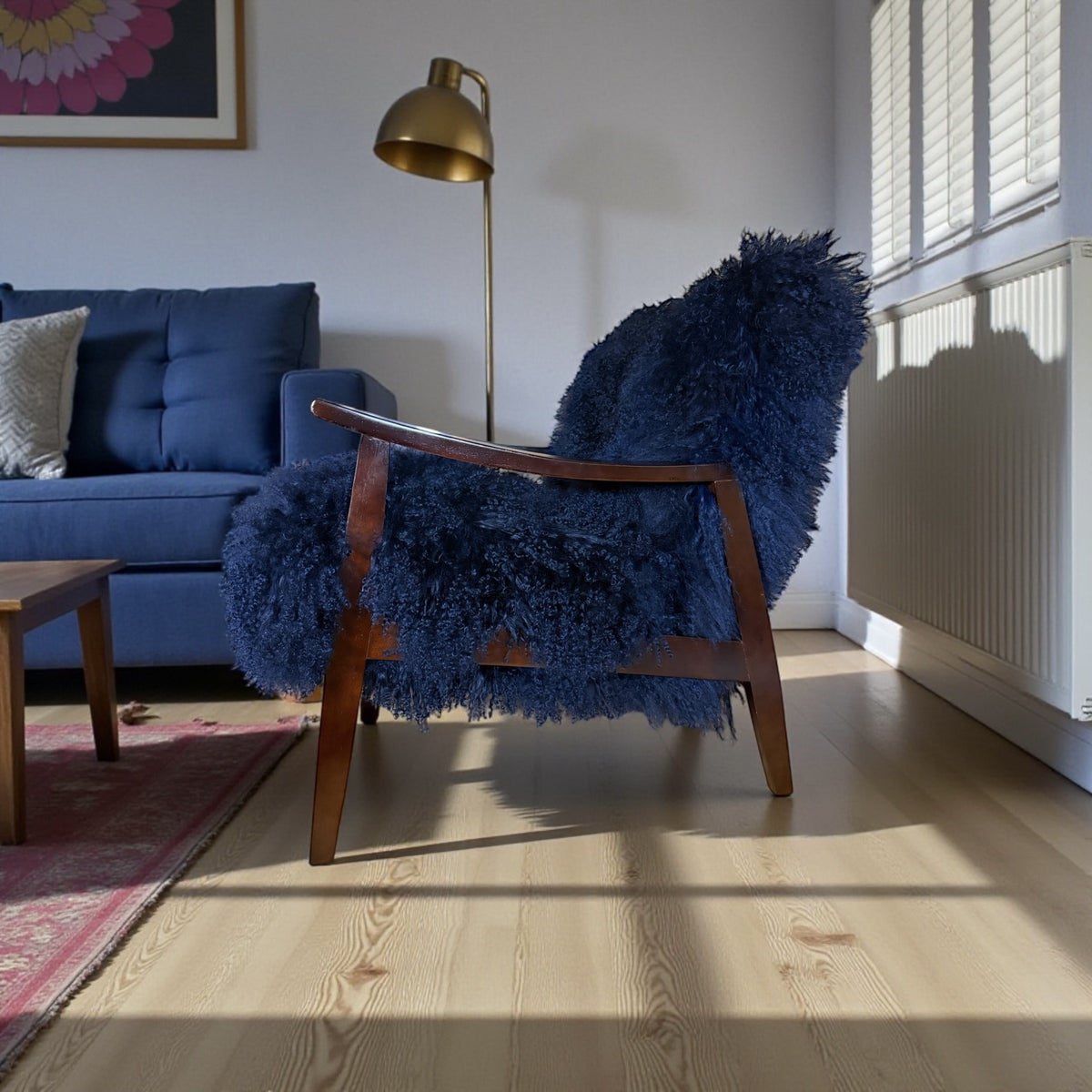 Handmade cobalt blue Mongolian fur accent chair with curved walnut arms in a sunny living room, side view